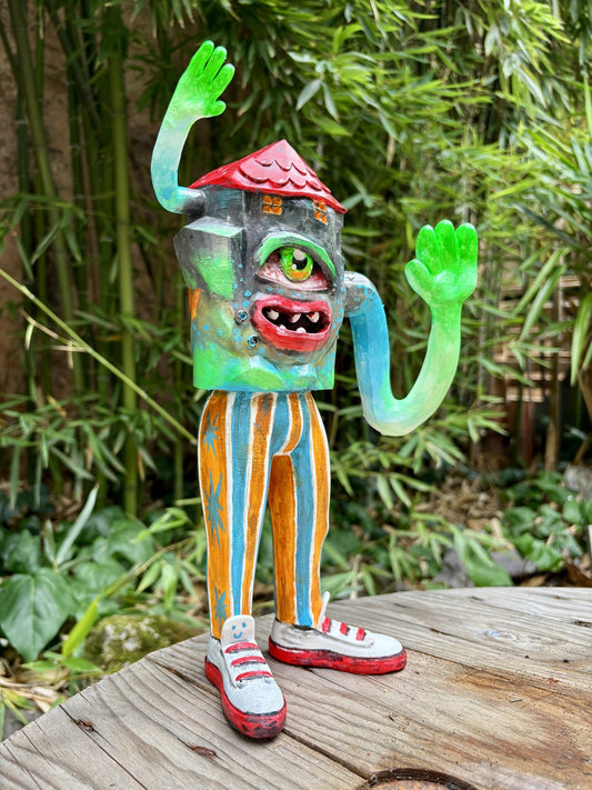 Weird Home di Max Petrone, art toy da collezione: vista tre quarti con occhio verde, bocca rossa e gambe a righe