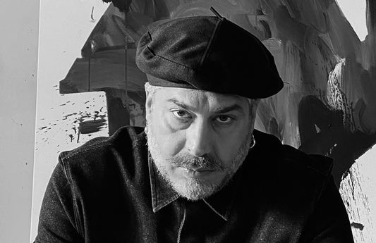 Max Petrone nel suo studio accanto alle opere