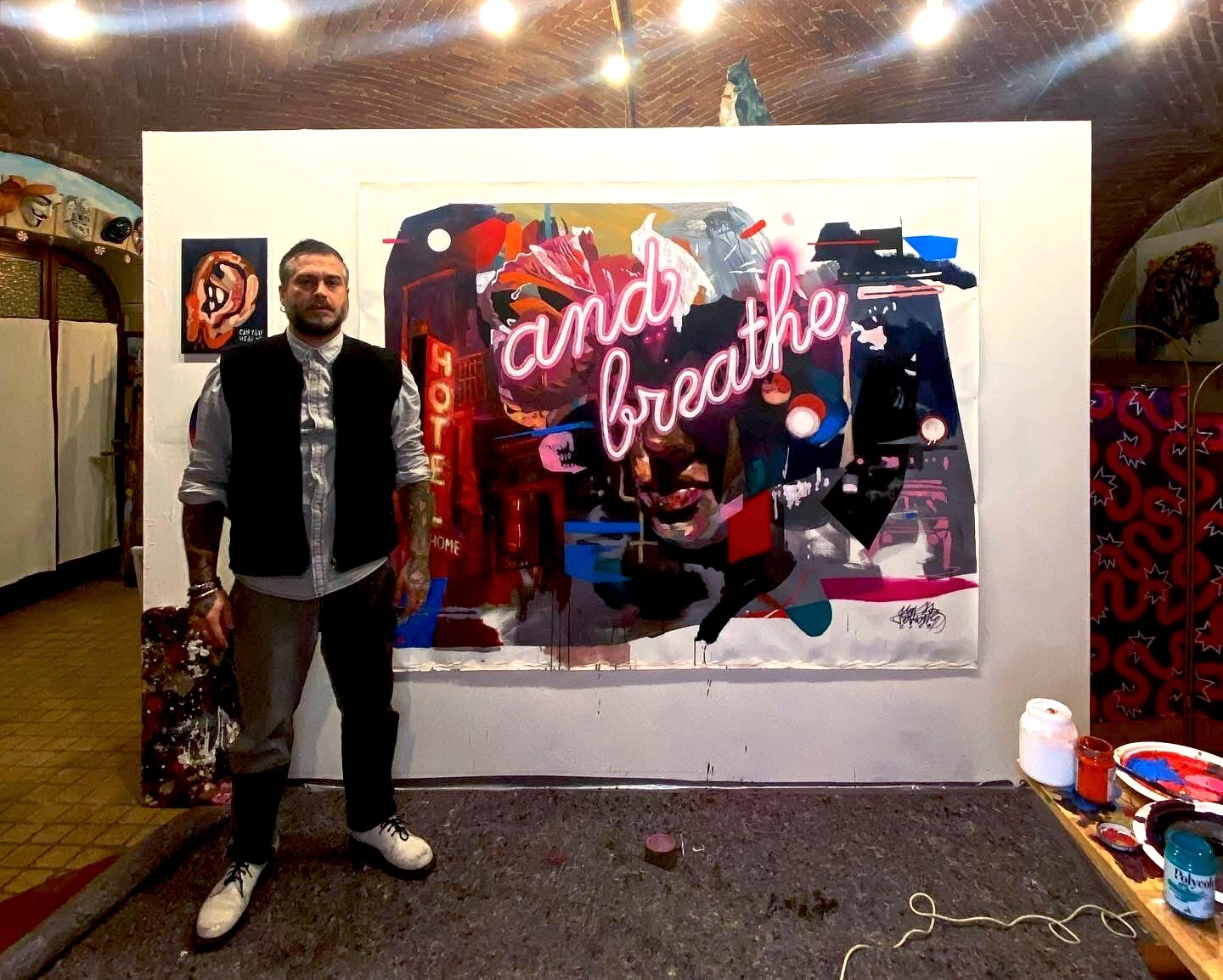Max Petrone accanto al dipinto Hotel My Home and Breathe in studio