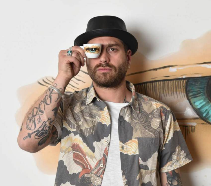 Max Petrone con una tazzina Coffee Drawings sull'occhio, illy Art Collection
