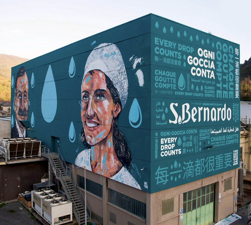 Il murale di Max Petrone per Acqua S.Bernardo sullo stabilimento di Garessio, con Ottavio Rovere e una lavoratrice simbolica