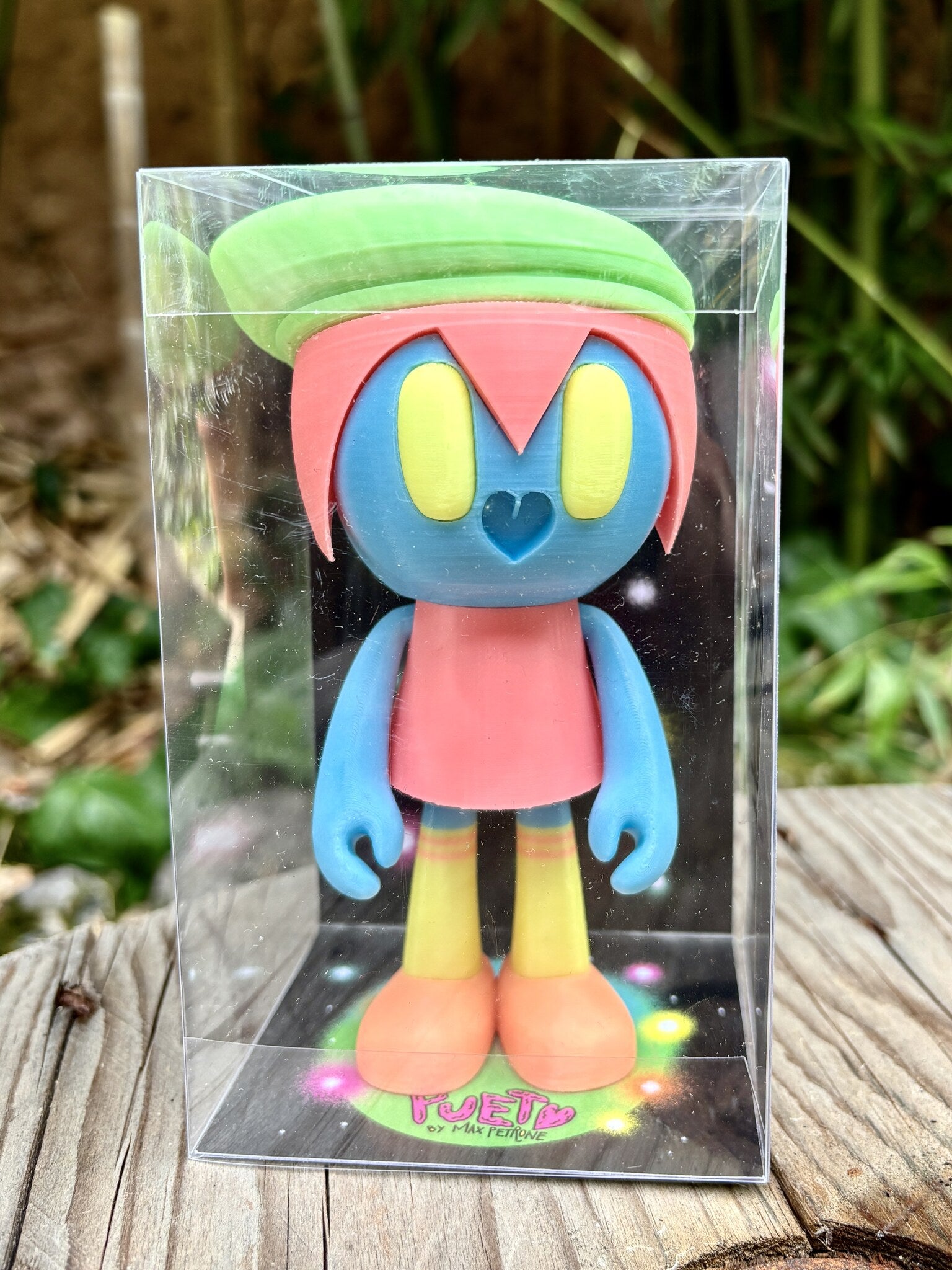 Pueta di Max Petrone, art toy da collezione glow in the dark con béret verde, occhi gialli e nasino a cuore, vista frontale in box