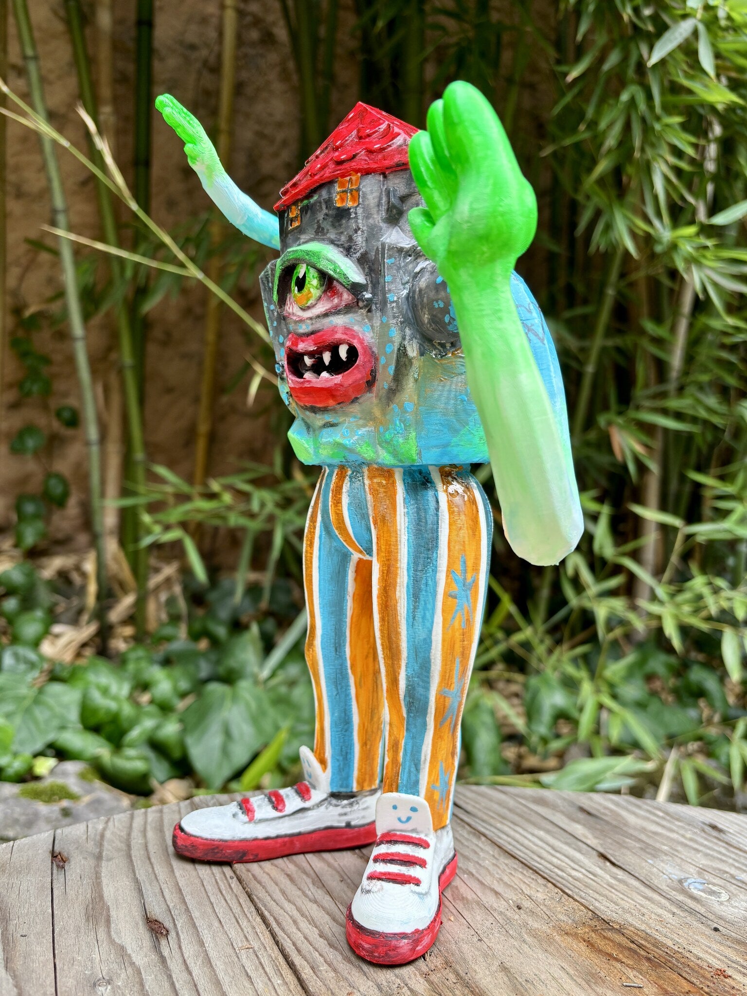 Weird Home, art toy Max Petrone: dettaglio laterale con braccio fosforescente, pantaloni a righe e sneakers rosse